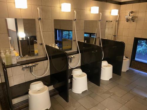 a bathroom with three toilets and three sinks and mirrors at Green Rich Hotel Hiroshima Shinkansenguchi (Artificial hot spring Futamata Yunohana) in Hiroshima