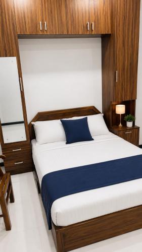 a bedroom with a large bed with wood paneling at Grand Stay Hotel in Seeduwa