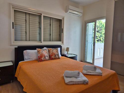 a bedroom with a bed with two towels on it at Villa Larnaca Bay Resort in Oroklini