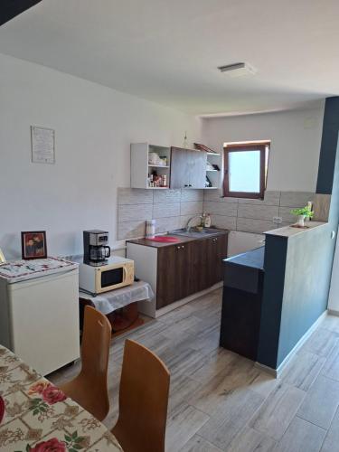 a kitchen with a table and some chairs in it at Cozy House Corbu in Corbu