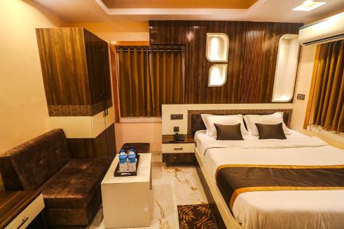 a hotel room with two beds and a couch at Mohar Residency - VIP Road in kolkata