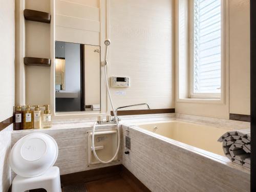 a bathroom with a tub and a toilet and a sink at Biwa 広々テラス bbq 無料駐車場 湖まで徒歩3分 in Takashima