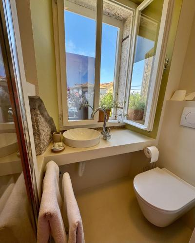 a bathroom with a sink and a toilet and a window at Peregrino Residence in Punat