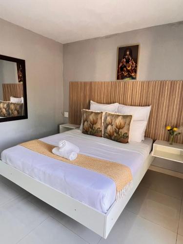 a bedroom with a large bed with a wooden headboard at Lamamie Suite Lodge in Thohoyandou