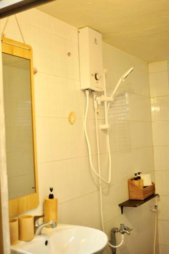 a shower in a bathroom with a sink and a mirror at Outdo'r Garden House in Tuy Hoa