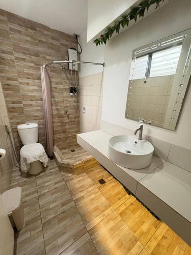 a bathroom with a sink and a shower and a toilet at 1775 Adriatico Suites in Manila