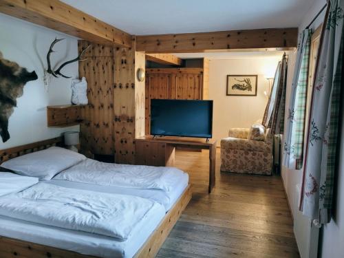 a bedroom with a bed and a flat screen tv at Berghotel Arthurhaus in Mühlbach am Hochkönig