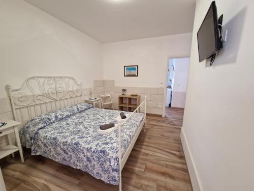a bedroom with a bed and a tv on a wall at B&B Mare di Ricordi Camera in San Foca