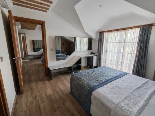 a bedroom with a bed and a desk and a mirror at Telmessos Neva Hotel - Halal-Non Alcoholic All Inclusive-Muhafazakar Hotel in Oludeniz