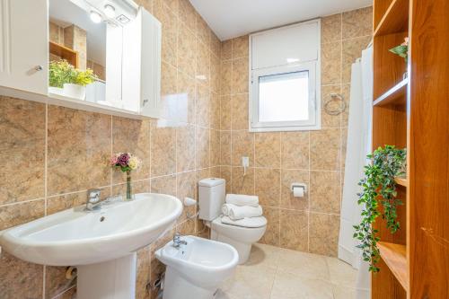 a bathroom with a sink and a toilet at Jouvacations Villa 3 Freser con piscina compartida in Empuriabrava