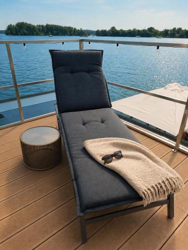 a chair with a pair of glasses sitting on a boat at Hausboot mit Sauna - TraumZeitBoot Heidi - exklusiver Festlieger in perfekter Lage am Scharmützelsee Bad Saarow in Bad Saarow