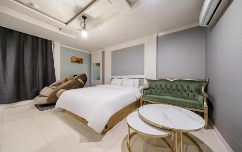 a bedroom with a bed and a table and a couch at Cats Hotel in Puch'ŏn-yŏk