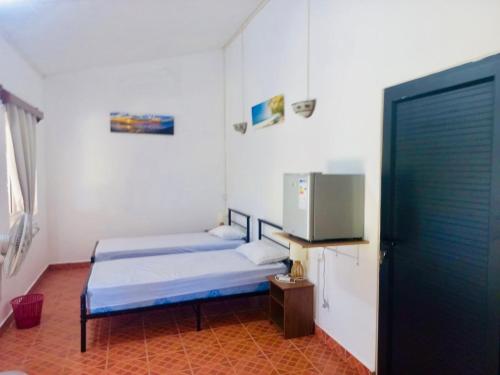 a room with two beds and a tv at Gîte Le Tropical in Rodrigues Island