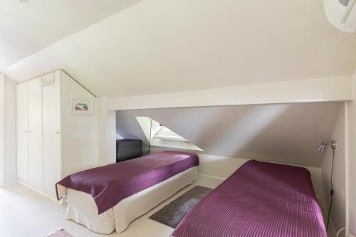 a bedroom with a purple bed and a staircase at Villa Tuuliniemi in Muurame
