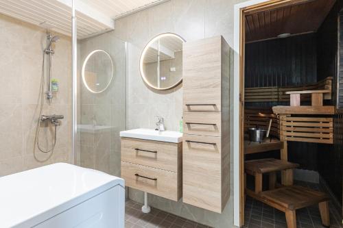 a bathroom with a white sink and a shower at Villa Tuuliniemi in Muurame
