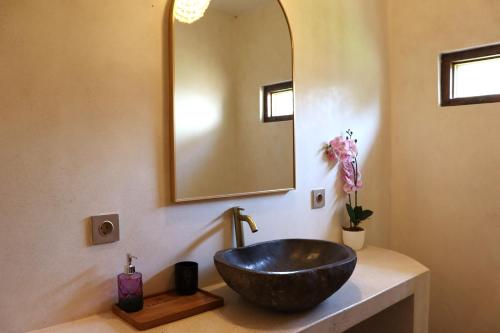 a bathroom with a black sink and a mirror at La Calma Villa in Gili Islands