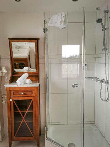 a bathroom with a shower and a sink and a mirror at Berghotel Arthurhaus in Mühlbach am Hochkönig