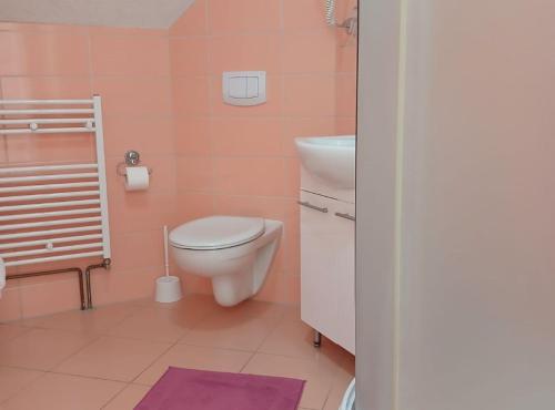 a pink bathroom with a toilet and a sink at Villa Lika in Plitvička Jezera