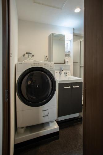 a washing machine in a bathroom with a sink at NIYS apartments 37type in Tokyo