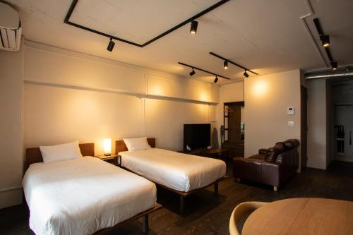 a hotel room with two beds and a table at NIYS apartments 37type in Tokyo