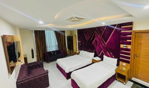 a hotel room with two beds and a chair at Hotel One Ten Mall Road Murree in Murree