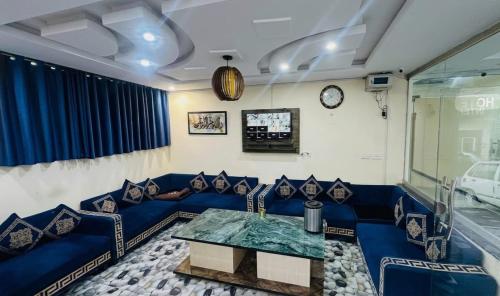 a living room with a blue couch and a table at Hotel One Ten Mall Road Murree in Murree