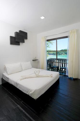 a bedroom with a bed with a view of the ocean at Aman Dan Laut in Perhentian Islands