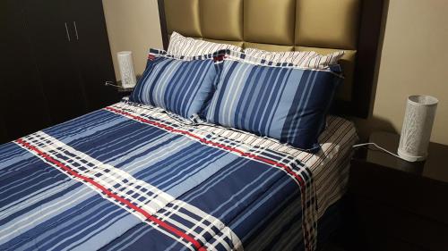 Cama con sábanas y almohadas de rayas azules y blancas en Lima Flats 3, en Lima