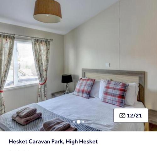 a bedroom with a bed and a window at 36 Ravens Nest large 3 bedroom lodge with views No sign written vans allowed on site in High Hesket