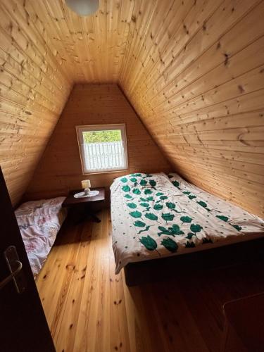 a bedroom with a bed in a wooden room at Agroturystyka i Domki Zacisze in Jarosławiec