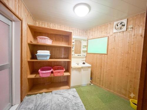 a bathroom with wooden walls and a sink and baskets at Mizubaso in Gujo