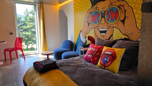ein Schlafzimmer mit einem Bett, an dessen Wand ein Gesicht aufgemalt ist in der Unterkunft Maison Triangle in Saint-Alban-dʼAy