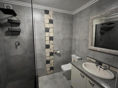 a bathroom with a toilet and a sink and a mirror at Laguna La Crete 33 in Uvongo Beach