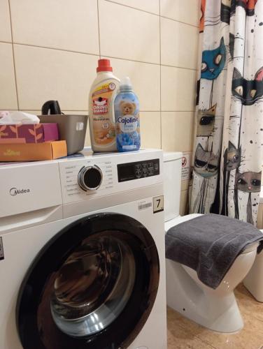 a washing machine with a bottle of detergent on top of it at 50 Cube - Mountain Nook Karpenisi in Karpenisi