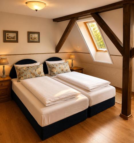 a bedroom with a large bed with a window at Kastélykert Vendégház in Bózsva