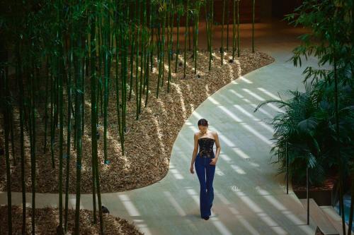 a woman walking down a walkway in a building at Hyatt Regency Beijing Wangjing in Beijing
