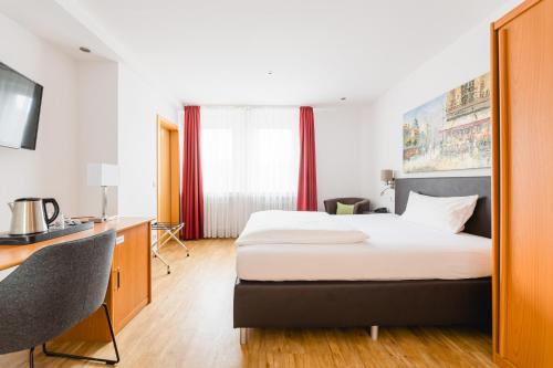 a hotel room with a bed and a desk at Hotel Bürger in Siegen