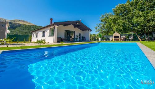 a swimming pool in front of a house at Holiday Home Nova Lux in Mostar