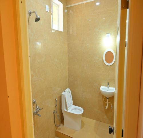 a bathroom with a toilet and a sink at Auro Green Villa in Pondicherry