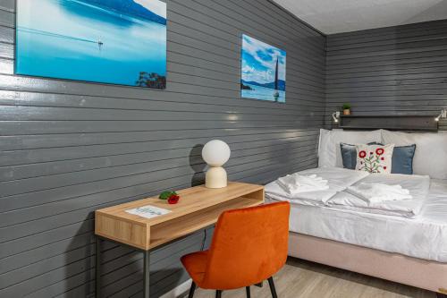 a bedroom with a bed and a desk with a chair at Villa My Garden in Zamárdi