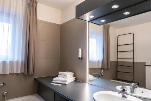 a bathroom with a sink and a mirror at Hotel Apostroff in Koksijde