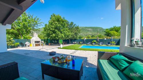 a patio with a couch and a table and a pool at Holiday Home Nova Lux in Mostar