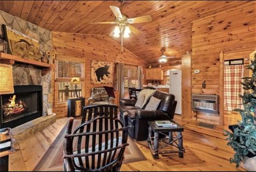a living room with a fireplace and a ceiling fan at Pet-Friendly Mountain Heaven - Hot Tub and Fire Pit in Blue Ridge