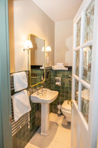 a bathroom with a sink and a toilet and a mirror at Gleeson's Roscommon in Roscommon