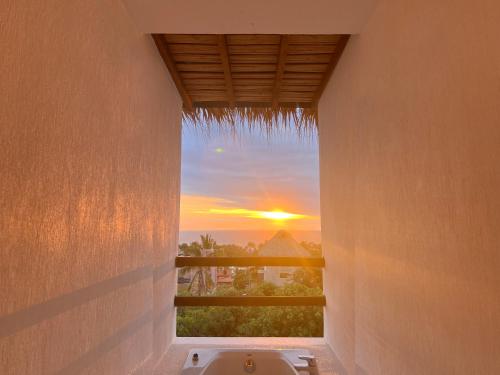 a view of a sunset from a bathroom window at Punta Kai Hotel & Hostal in Puerto Escondido