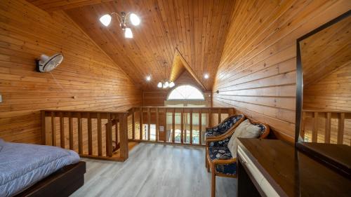 a bedroom in a log cabin with a bed and a window at Jeju seawalk in Namwon