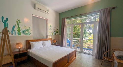 a bedroom with a bed and a large window at Côn Đảo Home in Con Dao