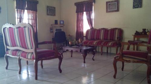a living room with two chairs and a table at Don Santiago Guesthouse Downtown in San Ignacio