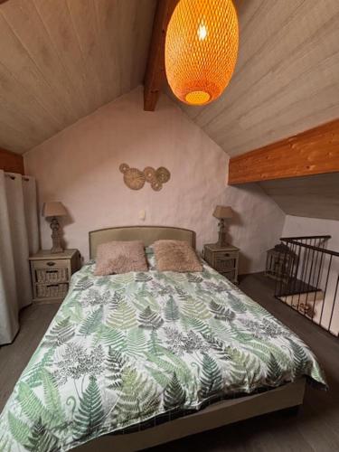 a bedroom with a bed with a green and white comforter at Gîte de Corbion une envie d'Ailleurs 6personnes et le Pt Bonheur 2 personnes in Leignon