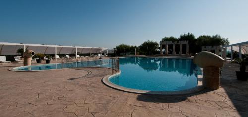 a large swimming pool in the middle of a resort at Agriturismo La Maddalena in Acate